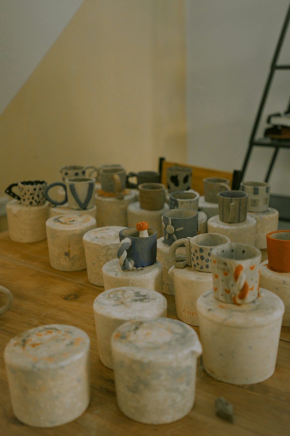 Handcrafted ceramic mugs and cups on wooden table.